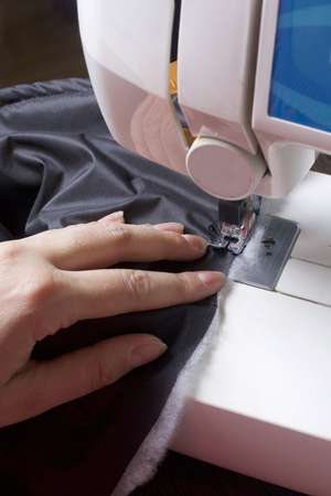 Sewing clothes by an individual entrepreneur. A woman is working on a sewing machine. Staples the...