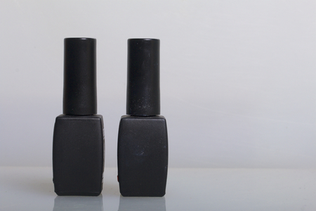 Nail coating with gel-varnish. Gel-lacquer in black bottles stands on a white surface.の写真素材
