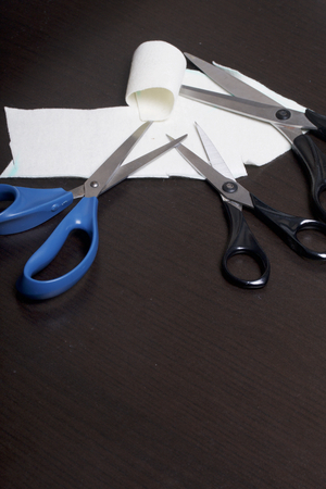 On the surface of the table are three pairs of scissors and a patch of excised tissue.の写真素材