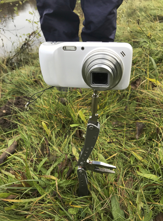 Photographing using improvised means. A compact camera is mounted on a folding knife, stuck into the...