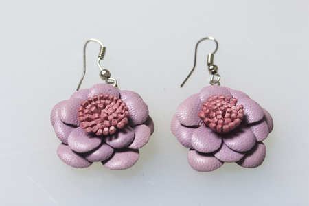 Women's costume jewelery. Earrings made of leather, handmade. Lie on a white surface. View from above.の写真素材