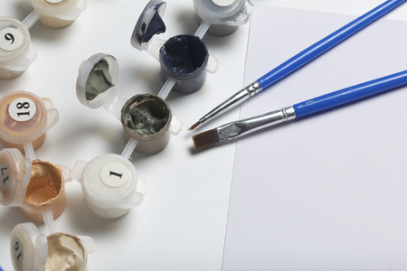 Paints for drawing by numbers. Several containers with paint are open.の写真素材