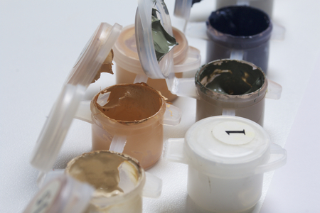 Paints for drawing by numbers. Several containers with paint are open.の写真素材