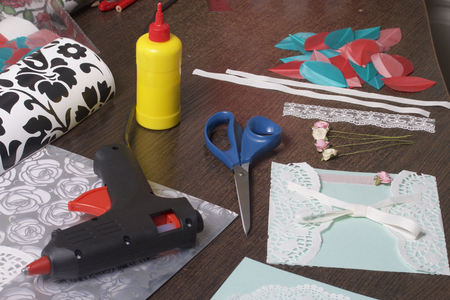 The girl is engaged in making greeting cards at home. Using paper, lace, braid and other materials.の写真素材
