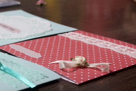 The girl is engaged in making greeting cards at home. Using paper, lace, braid and other materials.の写真素材