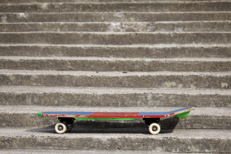 A skateboard stands on a concrete staircase.の写真素材