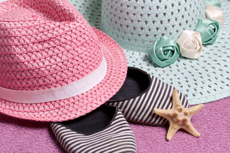 Going on vacation on the beach. Hat for protection from the sun. Beach sneakers and Starfish. Against the background of a beach towel.の写真素材