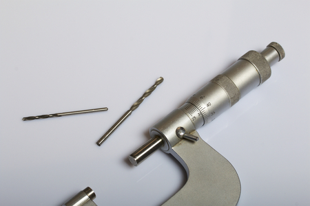 Micrometer with a circular scale for external measurements and a measuring range of 25 - 50 mm. Two drill bits. On a white background.の写真素材