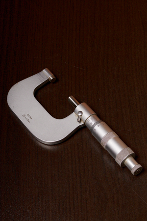 Micrometer with a circular scale for external measurements and a measuring range of 25 - 50 mm. On a dark background.の写真素材
