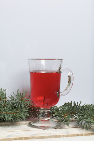 Blue spruce branches on a wooden box of boards, painted in white. Nearby is a glass of red wine.の写真素材