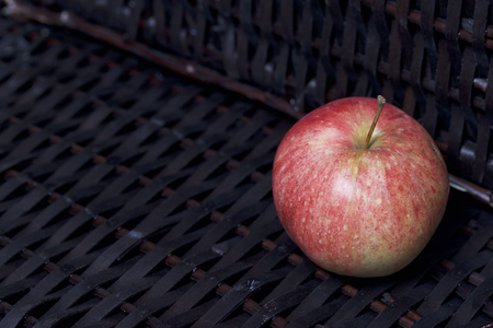 Ripe aromatic apples on the background of a wicker basket of vines.の写真素材