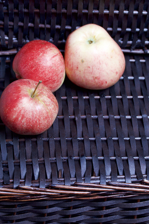 Ripe aromatic apples on the background of a wicker basket of vines.の写真素材