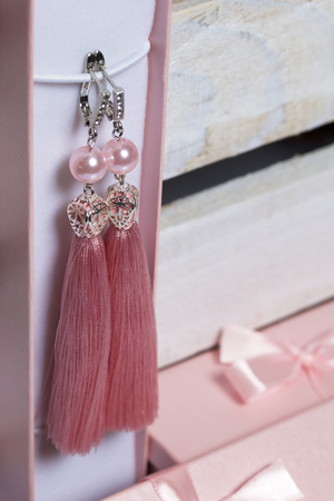 Earrings made of viscose handmade. Together with wrapping gift boxes. Against the background of a wooden box.の写真素材