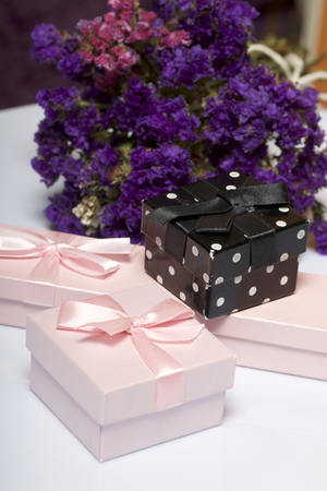 Wrapping presents. Gift boxes. Next is a bouquet of autumn dried flowers. On a white background.の写真素材