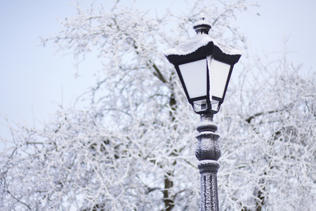 Old-fashioned lantern in a winter park. Everything around is covered with thick frost.の写真素材