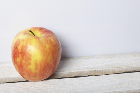 Ripe juicy apples. They lie on a wooden box. On a white background.の写真素材