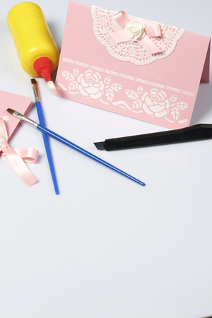 Making greeting cards from paper, cardboard and tape. Nearby on the surface are tools for its manufacture.の写真素材