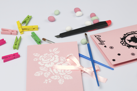 Making greeting card from paper, cardboard and tape. Nearby on the surface are tools for its manufacture and decorative accessories.の写真素材