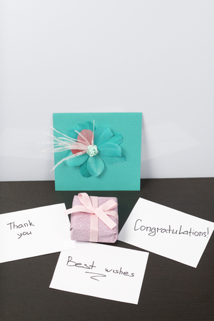 Handmade greeting cards. Near gift in wrapping paper, tied with a ribbon. Original gift.の写真素材