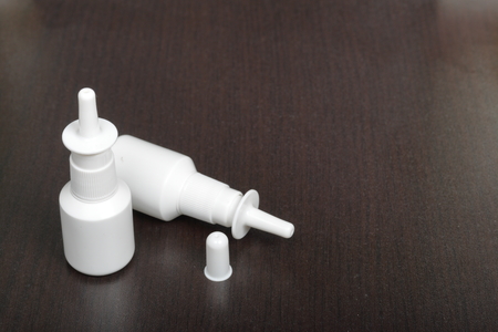 Nasal spray cans for the treatment of rhinitis. On a dark background.の写真素材