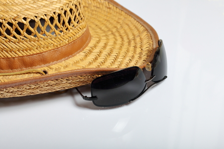 Accessories for summer holidays. Straw hat and sunglasses. On a white background.の写真素材