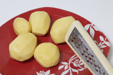 Peeled potatoes on a plate. Minced meat steaks with potatoes, eggs and cheese. Cooking steps and ingredients.の写真素材