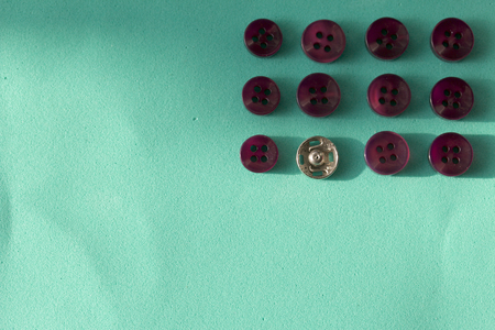 Buttons laid out in a row on a turquoise background. In the style of flat lay.