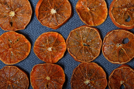Tangerines are cut into slices and dried to decorate desserts. On a gray background.の写真素材