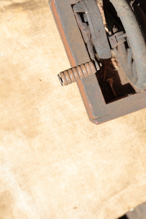 Old sewing machine, with manual drive. Covered with corrosion, dust and cobwebs. It stands on a...