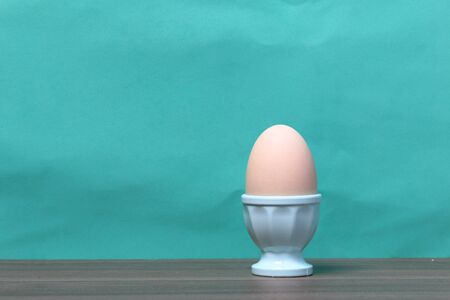 Boiled egg in poached pink. Against the background of mint color.