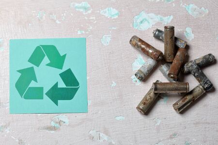 Spent batteries lie on the surface with peeling paint. Covered with corrosion. Nearby is the...