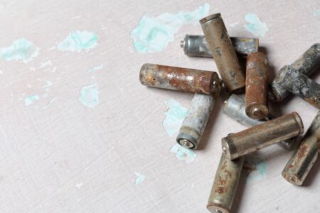 Spent batteries lie on the surface with peeling paint. Covered with corrosion. Recycling and environmental protection.の写真素材