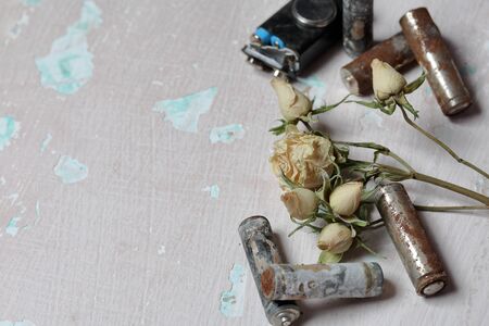 Spent batteries lie on the surface with peeling paint. Covered with corrosion. Nearby is a withered...
