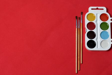 Accessories for drawing. Compasses, ruler and notebook. Against the background of coral color.