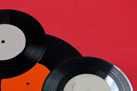 Old vinyl records. Worn and dirty. They lie on the surface of coral color.