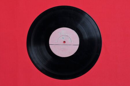 Old vinyl record. Worn and dirty. They lie on the surface of coral color.の写真素材