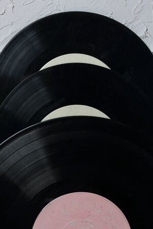 Old vinyl records. Worn and dirty. They lie on the surface covered with decorative plaster.の写真素材