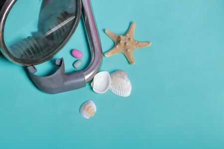 Starfish, shells and colored pebbles. Mask with a snorkel for scuba diving. They lie on a rough...
