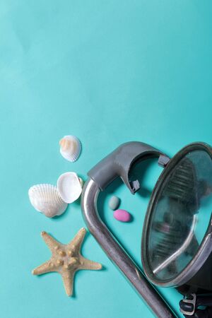 Starfish, shells and colored pebbles. Mask with a snorkel for scuba diving. They lie on a rough linen fabric.の写真素材
