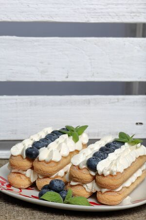Cakes made from Italian savoyardi cookies and cream. Decorated with blueberries and mint leaves....