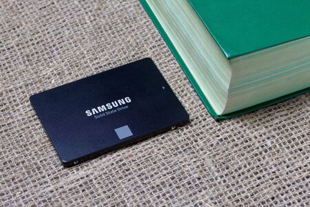 MINSK, BELARUS - NOVEMBER 25, 2019: Samsung 860 Evo 500GB SSD Hard Drive. Nearby are two thick books.のeditorial素材