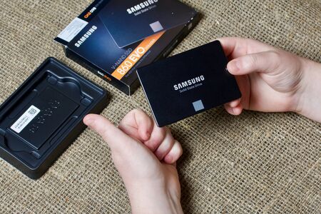 MINSK, BELARUS - NOVEMBER 25, 2019: A man takes out a package of Samsung 860 Evo 500GB SSD Hard...