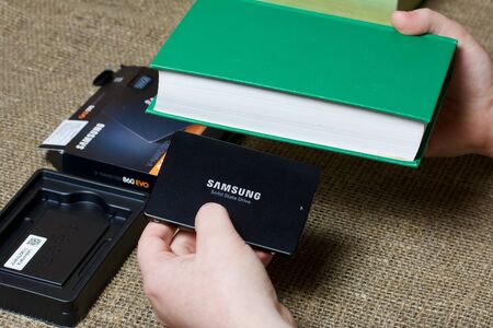 MINSK, BELARUS - NOVEMBER 25, 2019: A man holds in one hand the Samsung 860 Evo 500GB SSD Hard...