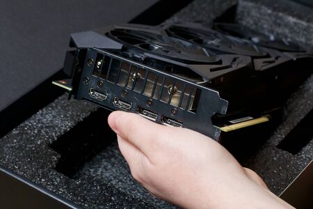 MINSK, BELARUS - NOVEMBER 25, 2019: A man opens the package with the ROG Strix GeForce GTX 1660 Ti...