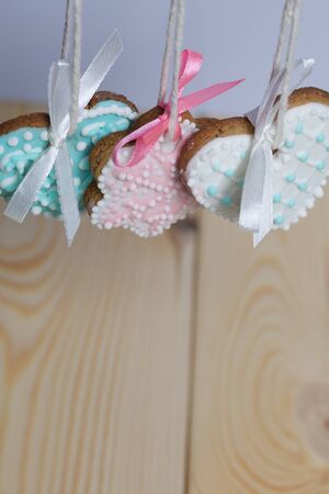 Spicy gingerbread cookie decorated with multi-colored sugar icing. Suspended on a cord. Decorated...