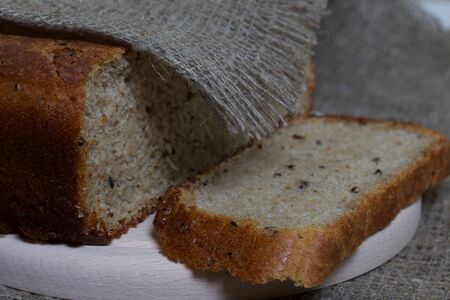 Freshly baked bread. A loaf of bread is cut and lies on a cutting board. The surface is covered with...