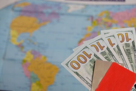 Hundred dollar banknotes. Bank cards. Against the background of a world map. Silhouettes of continents are visible on it.の写真素材