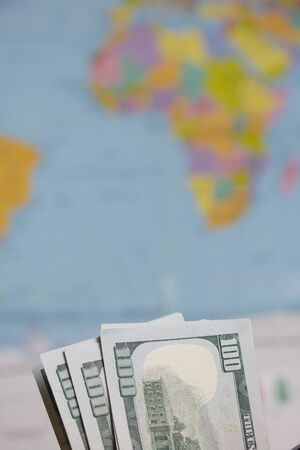 Hundred dollar banknotes. Against the background of a world map. The silhouette of Africa is visible...