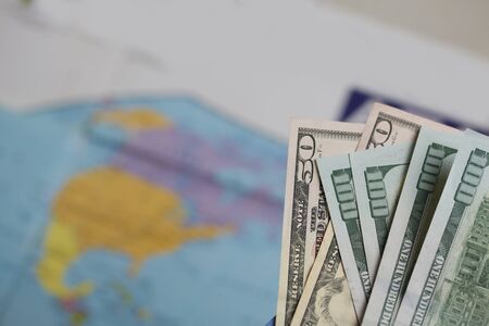Hundred dollar and fifty dollar bills. Against the background of a world map. It shows the...