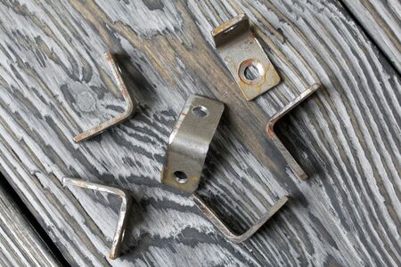 Metal corners with holes for screws. They lie on pine brushing boards painted black. World Labor...